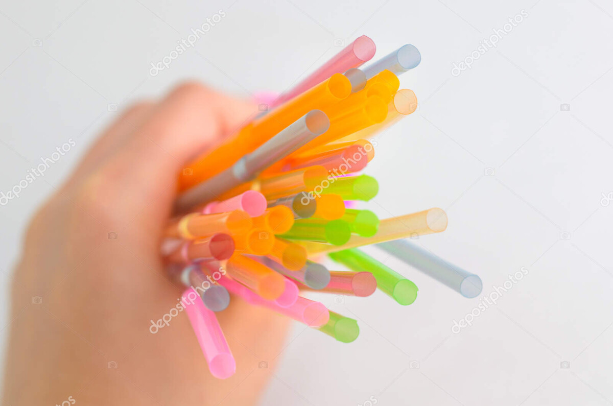 a bunch of multicolored plastic tubes in his hand on a white background